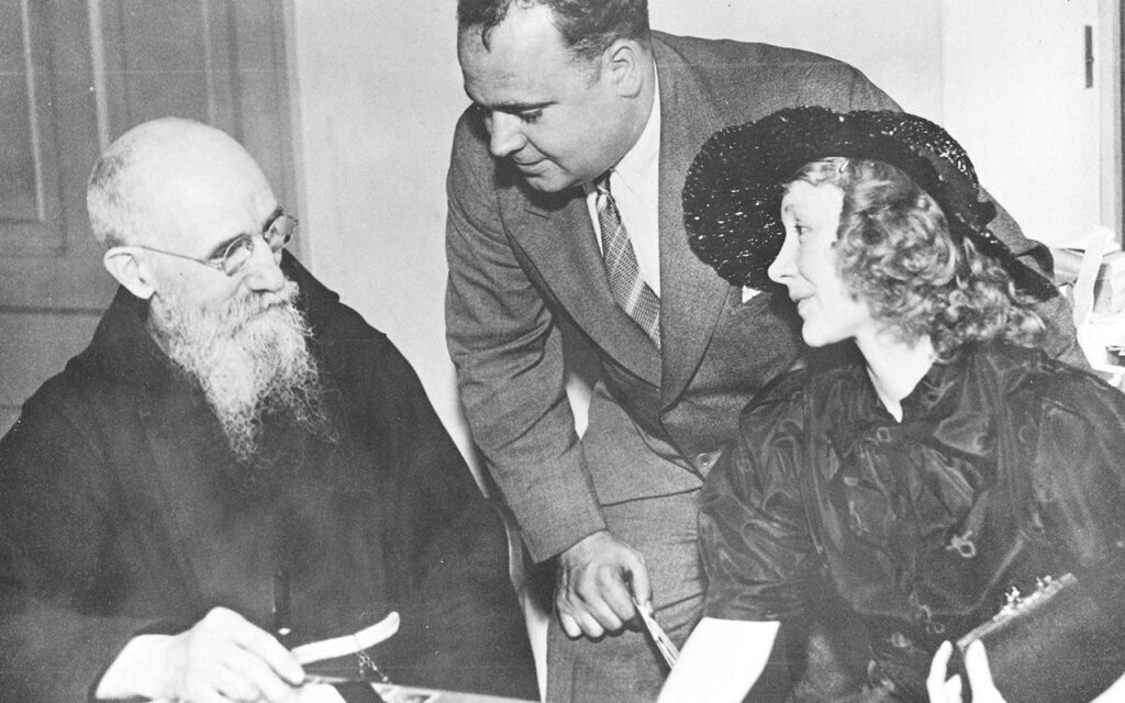 Blessed Solanus Casey meets with a couple in an office at the monastery